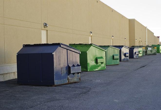 a pile of demolition waste sits beside a dumpster in a parking lot in Jamesport